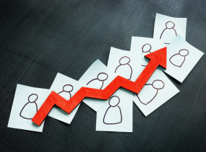 Red upward arrow over staff icons, showing business impact of CEFR-aligned Mandarin training for Malaysian teams