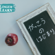Chalkboard with Japanese hiragana and apple, introducing Japanese conversation for Malaysian beginners at work
